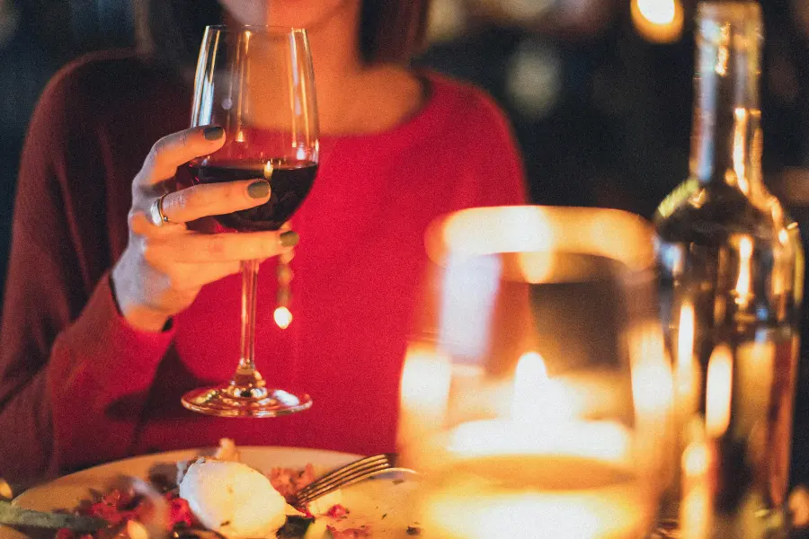 Lady sipping on a glass of wine.