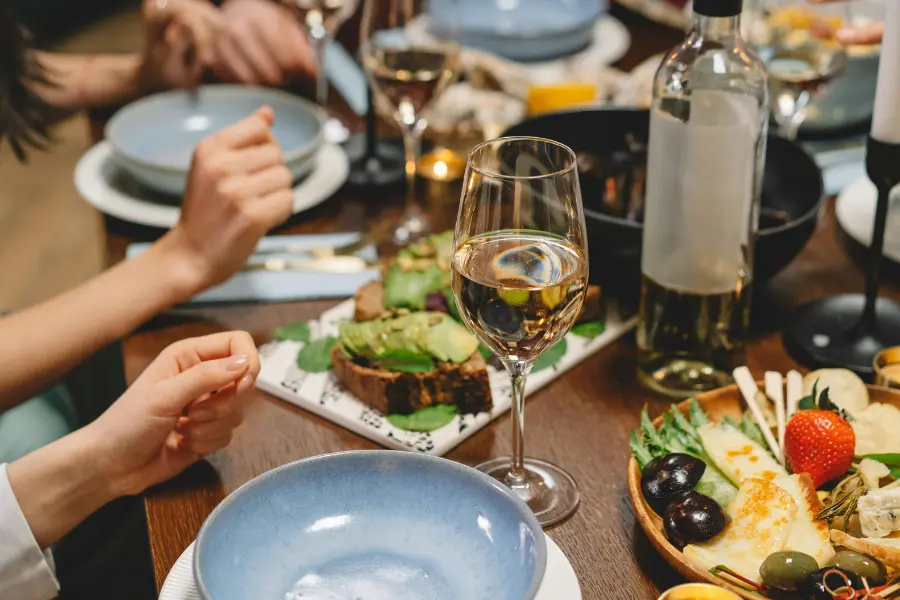 View of dining table setup with plated food and wine glasses
