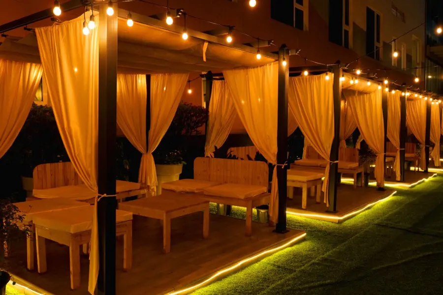 View of intimate evening cabana seating area, offering ambient lighting and a cozy dining experience.