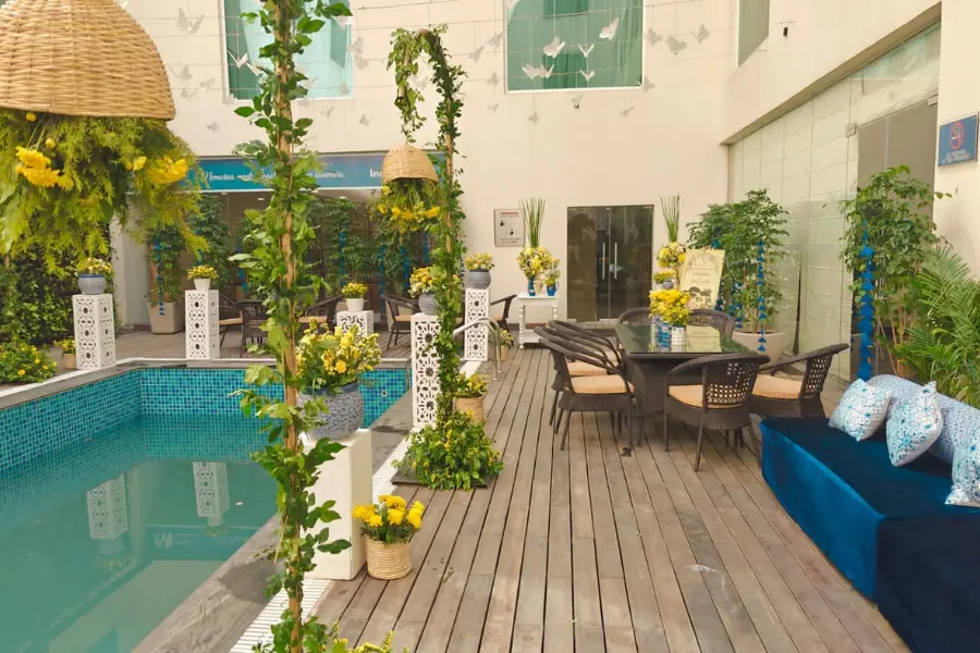 View of stylish poolside lounge adorned with floral decor, offering a relaxing space for guests.
